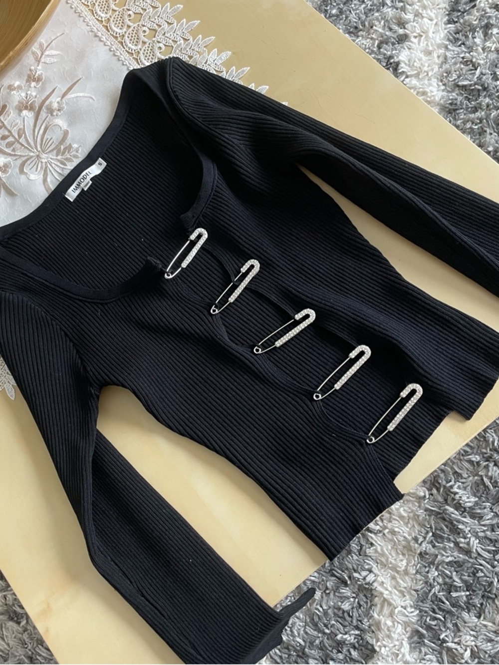 IMMODEL ribbed knit long-sleeve cardigan featuring safety pin closures.